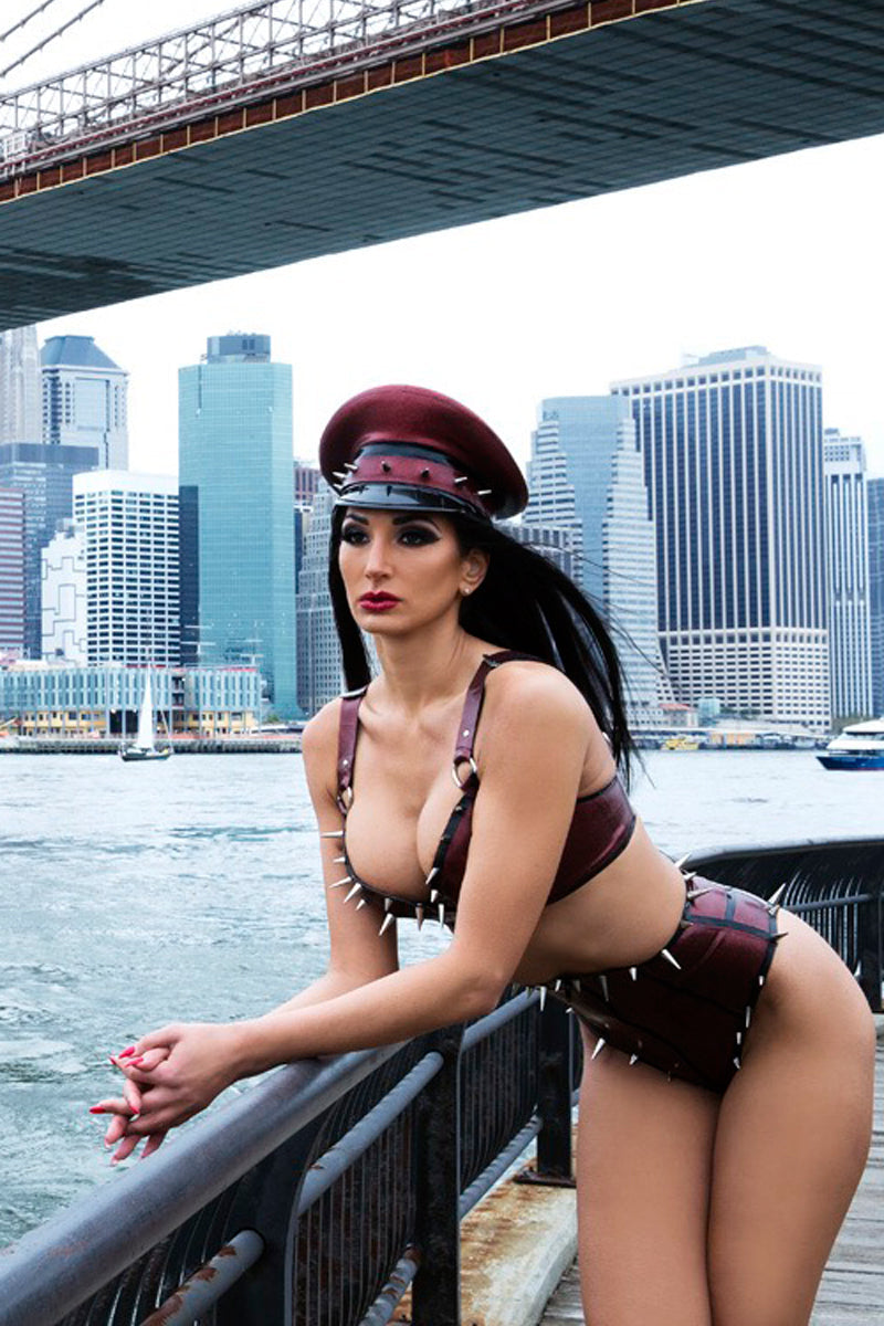 Woman in a latex outfit with a cityscape and bridge in the background