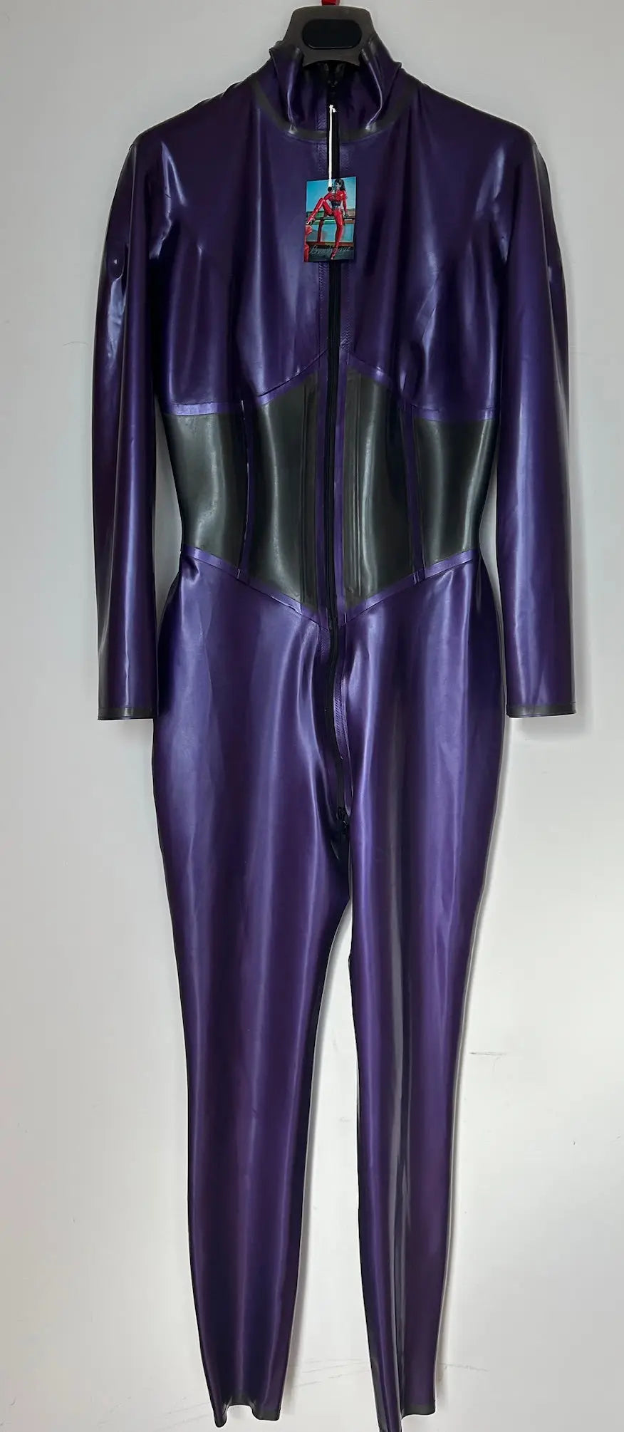 Purple and black latex catsuit on a hanger against a white background